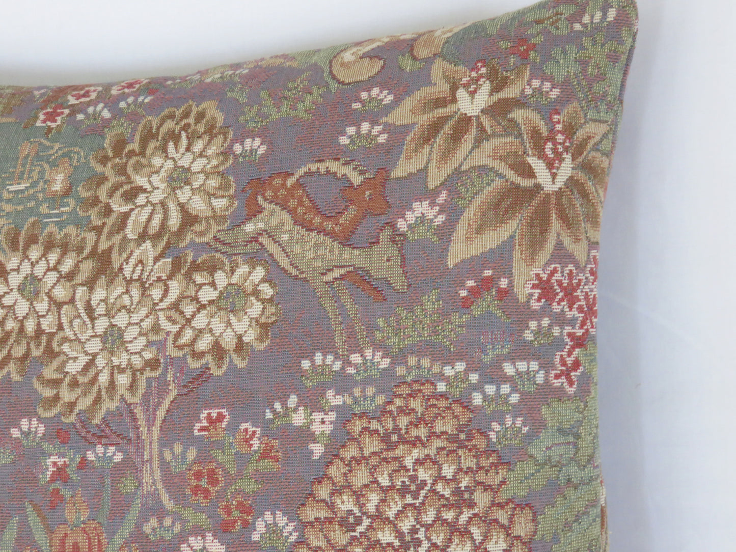 medieval garden tapestry pillow cover with animals and trees in shades of purple, green, and rust