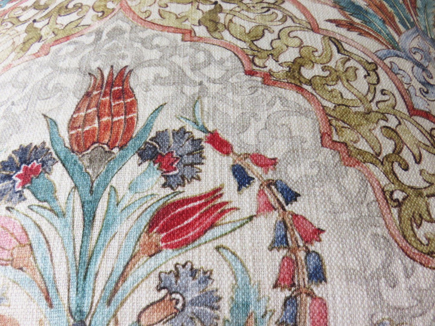 beautiful watercolor printed pillow cover on soft white cotton, featuring floral medallions and fretwork in hades of coral, aqua, red, blue, sage green, and grey