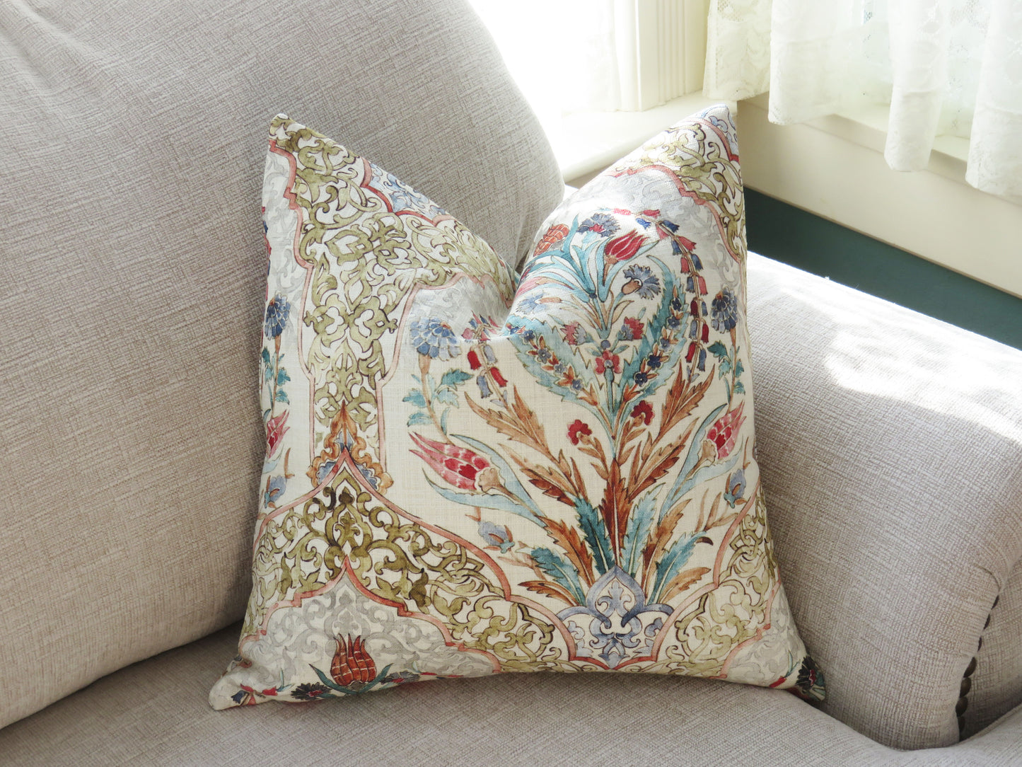 beautiful watercolor printed pillow cover on soft white cotton, featuring floral medallions and fretwork in hades of coral, aqua, red, blue, sage green, and grey