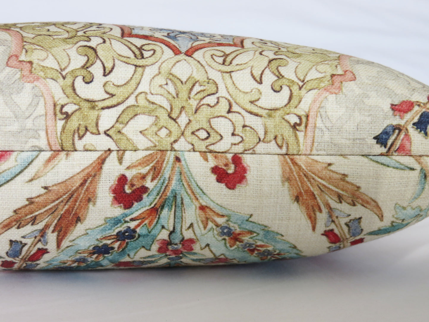 beautiful watercolor printed pillow cover on soft white cotton, featuring floral medallions and fretwork in hades of coral, aqua, red, blue, sage green, and grey